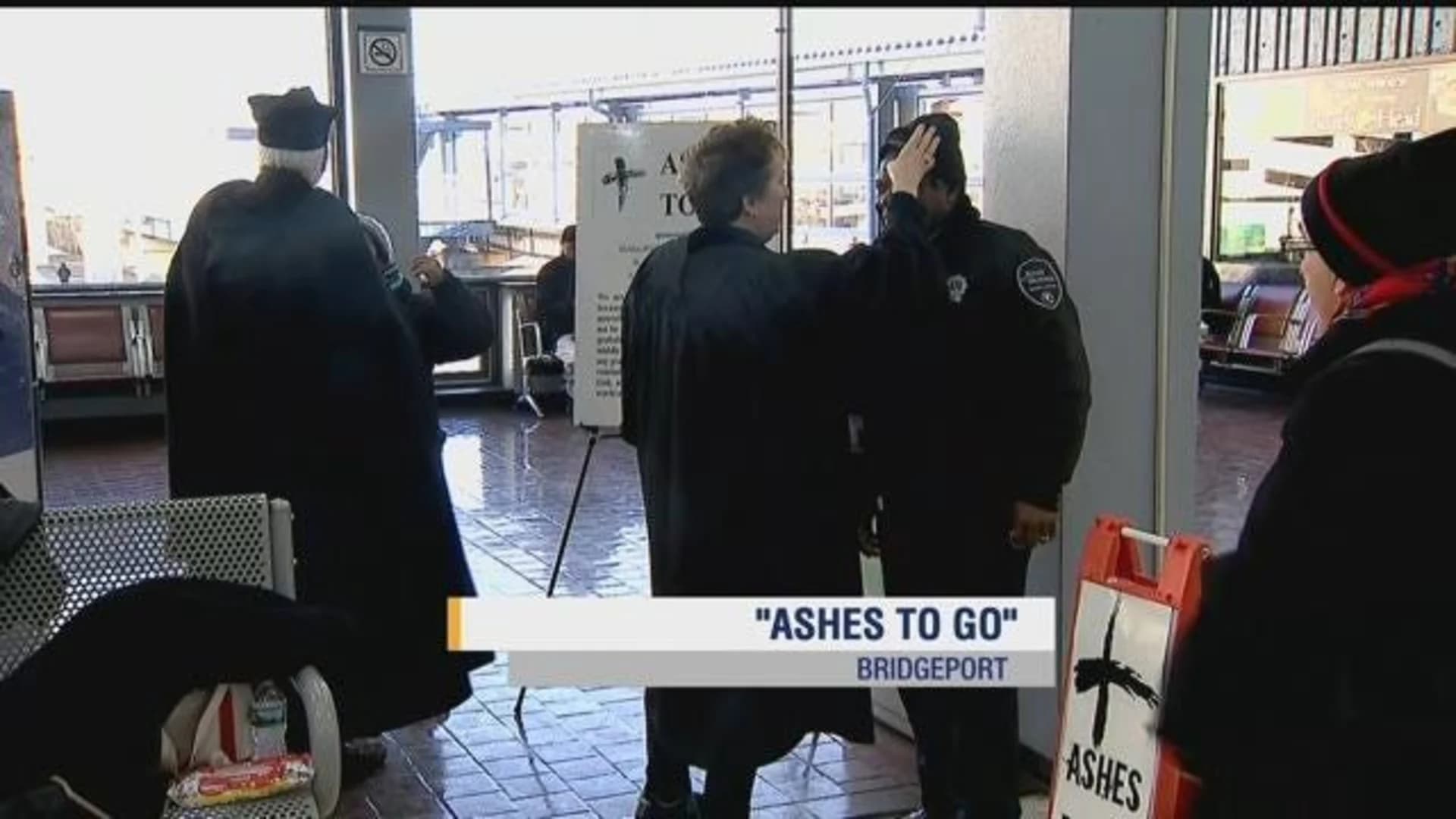 Clergy hand out ashes to commuters at Bridgeport train station