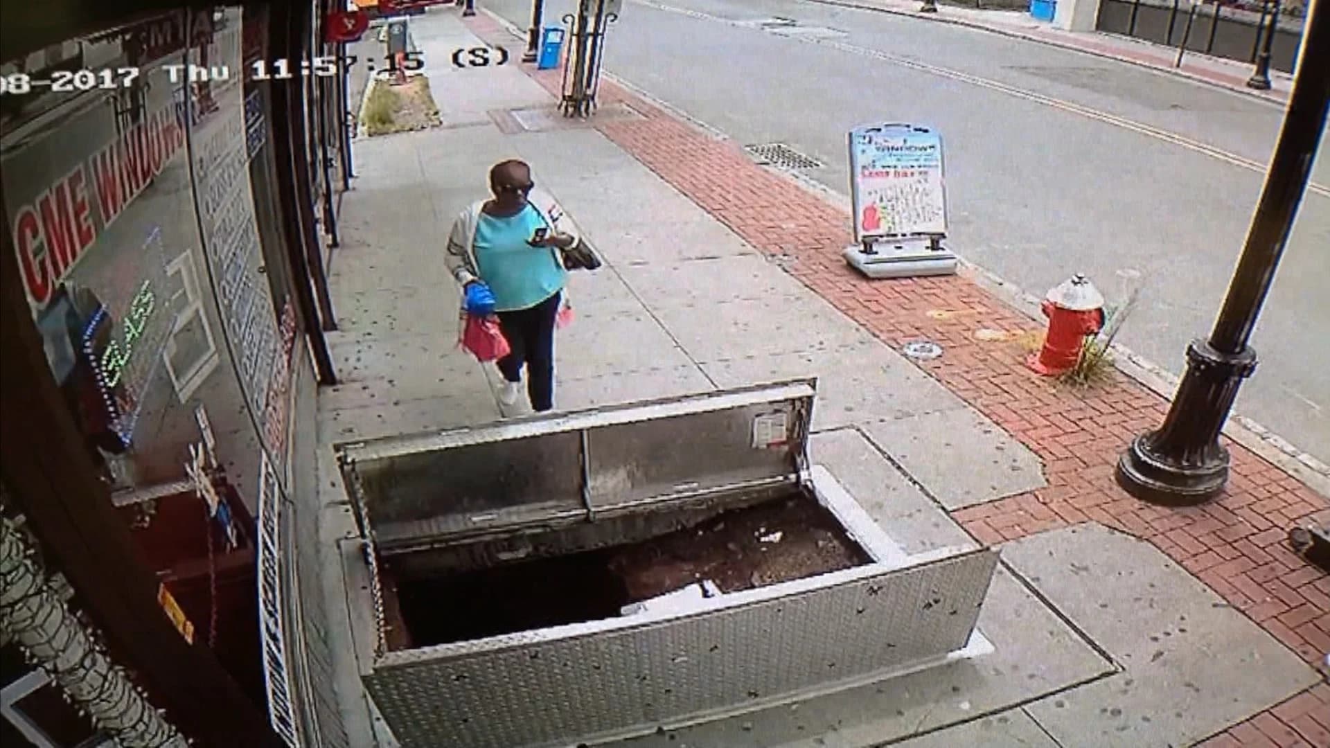 VIDEO: Woman falls though open sidewalk access door while on phone
